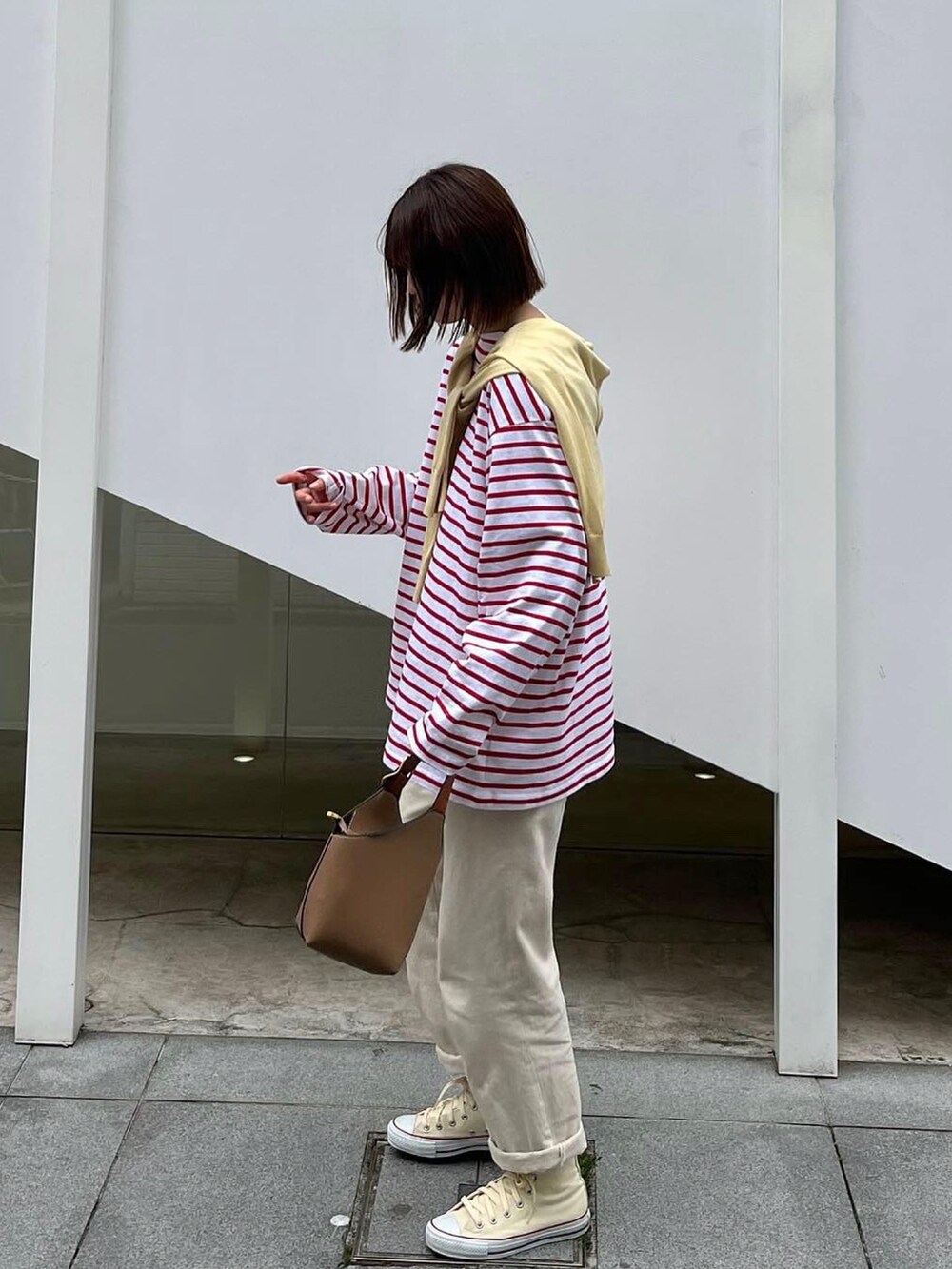 ホワイト系のデニムパンツ、ベージュ系のトートバッグ、ベージュ系のスニーカーを着用したレディースの春コーディネートの2枚目の写真