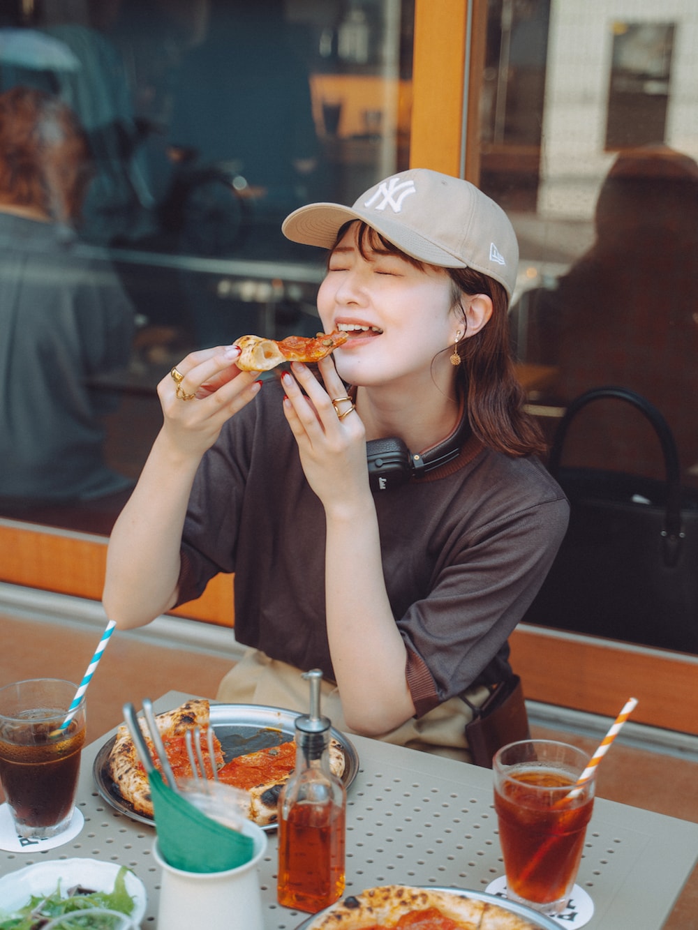 ベージュ系のチノパンツ、ブラウン系のショルダーバッグ、ブラウン系のモカシン/デッキシューズを着用したレディースの秋コーディネートの2枚目の写真