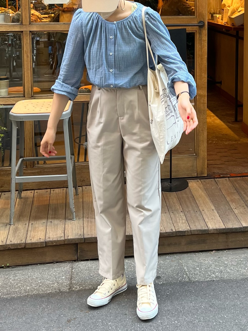 ベージュ系のスニーカー、ホワイト系のパンツ、ブルー系のシャツ/ブラウスを着用したレディースの春コーディネートの2枚目の写真