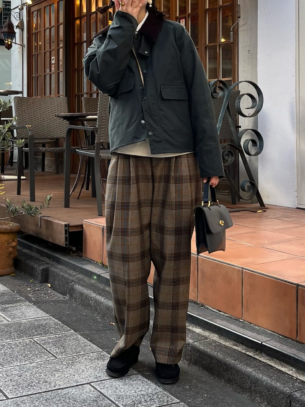 グリーン系のブルゾン、ブラウン系のスラックス、ブラック系のモカシン/デッキシューズを着用したレディースの冬コーディネートの2枚目の写真