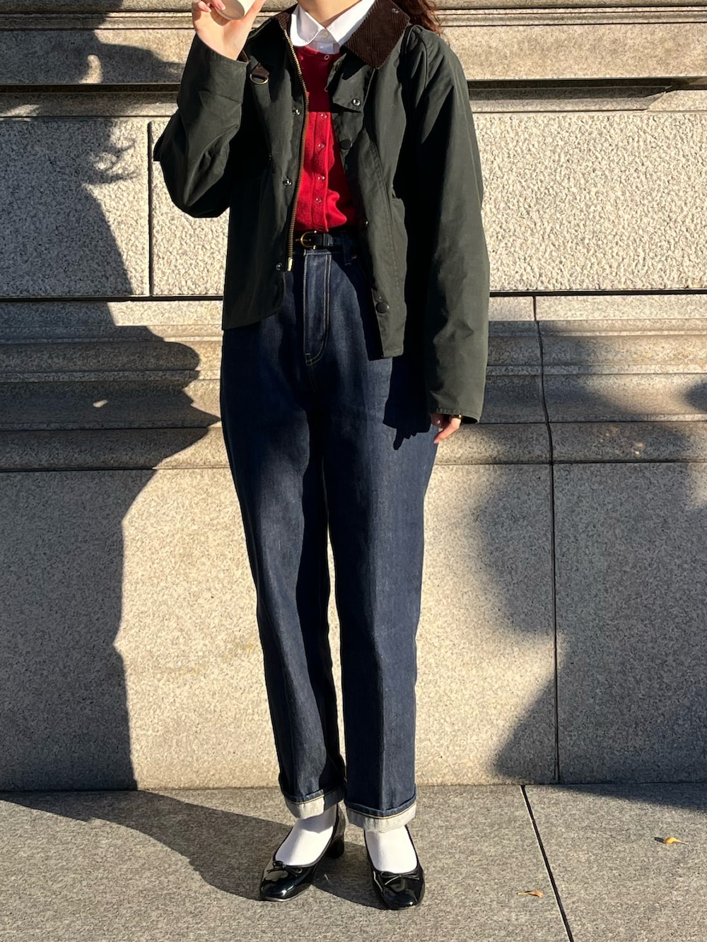 ブルー系のデニムパンツ、ブラック系のショルダーバッグ、グリーン系のブルゾンを着用したレディースの冬コーディネートの2枚目の写真