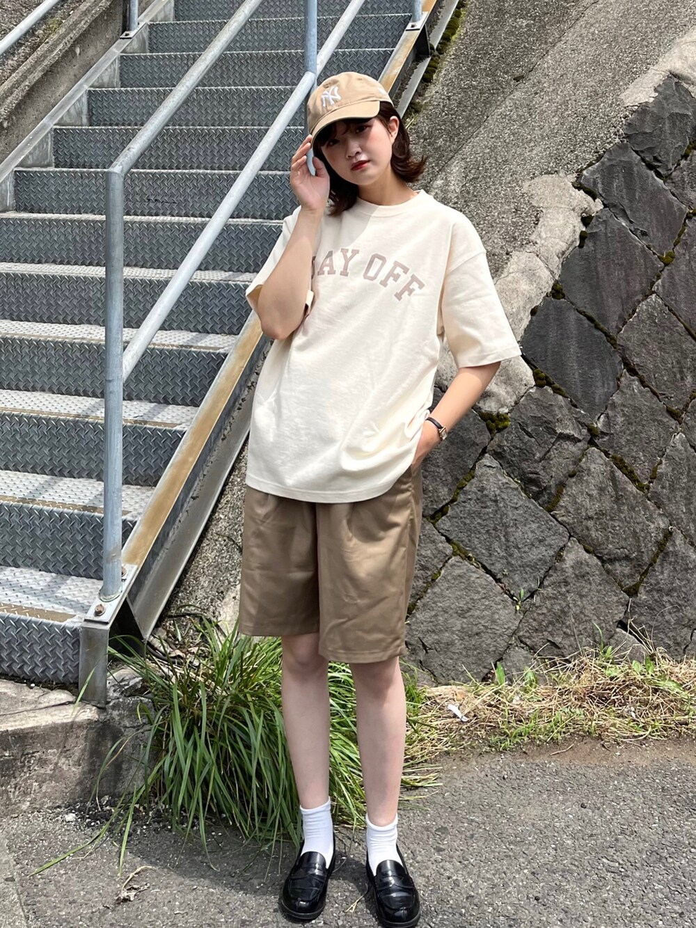 ブラック系のローファー、ベージュ系のTシャツ/カットソー、ベージュ系のスラックスを着用したレディースの夏コーディネートの2枚目の写真