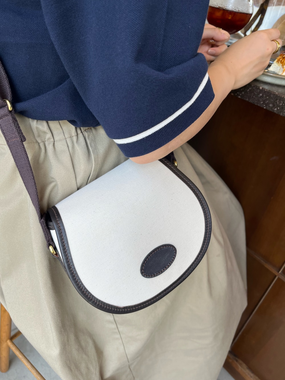 ベージュ系のサンダル、ベージュ系のスカート、ブルー系のポロシャツを着用したレディースの夏コーディネートの2枚目の写真