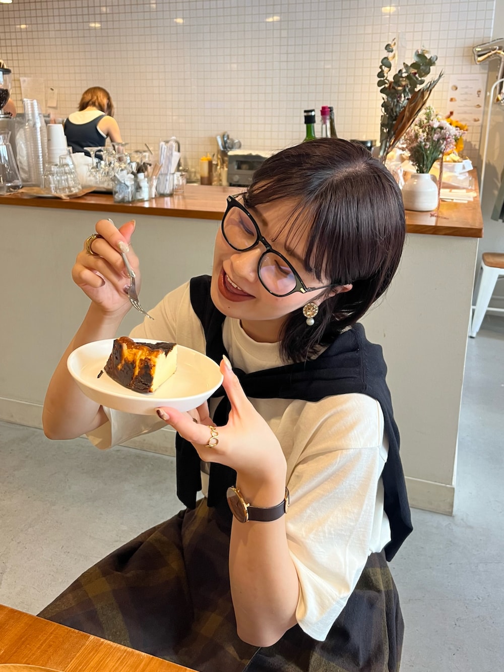 ブラック系のショルダーバッグ、ブラック系のローファー、ホワイト系のTシャツ/カットソーを着用したレディースの夏コーディネートの2枚目の写真