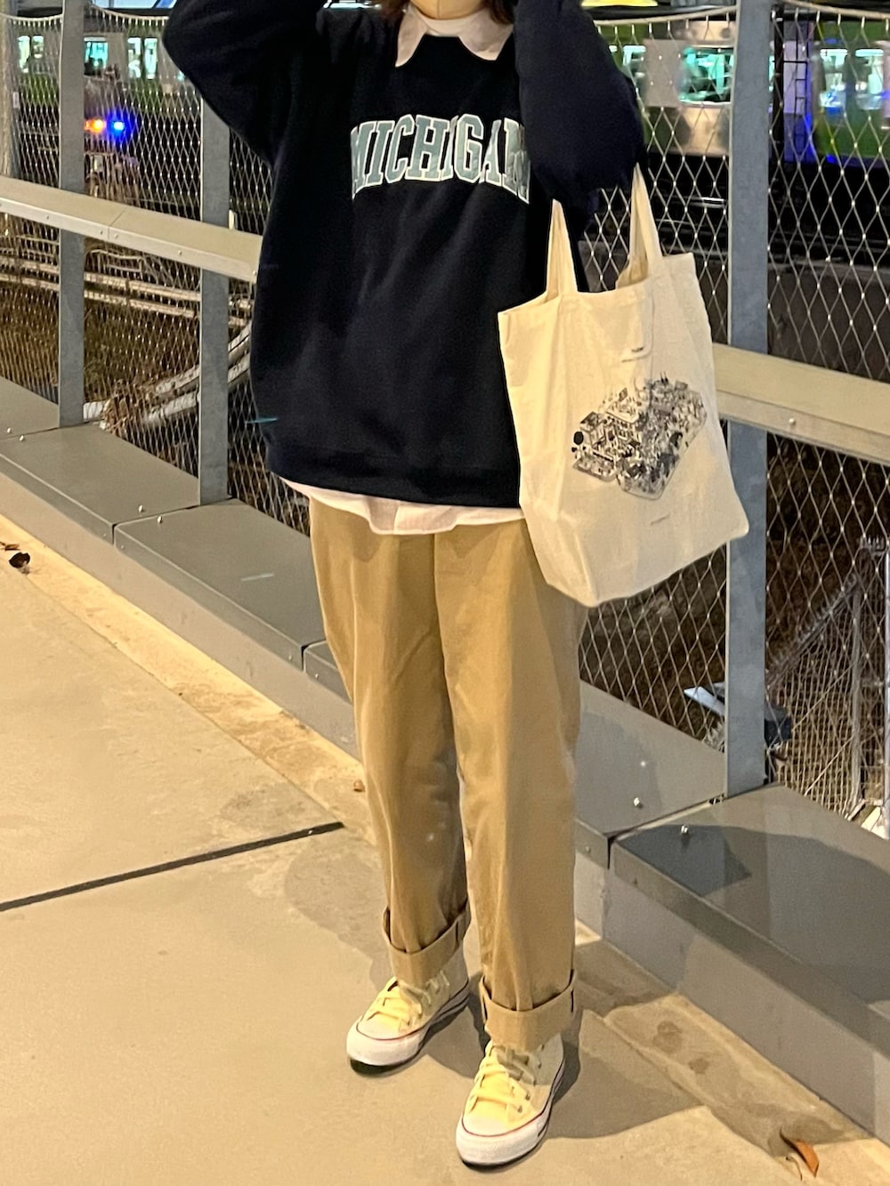 ブルー系のスウェット、ホワイト系のバッグ、ベージュ系のチノパンツを着用したレディースの春コーディネートの2枚目の写真