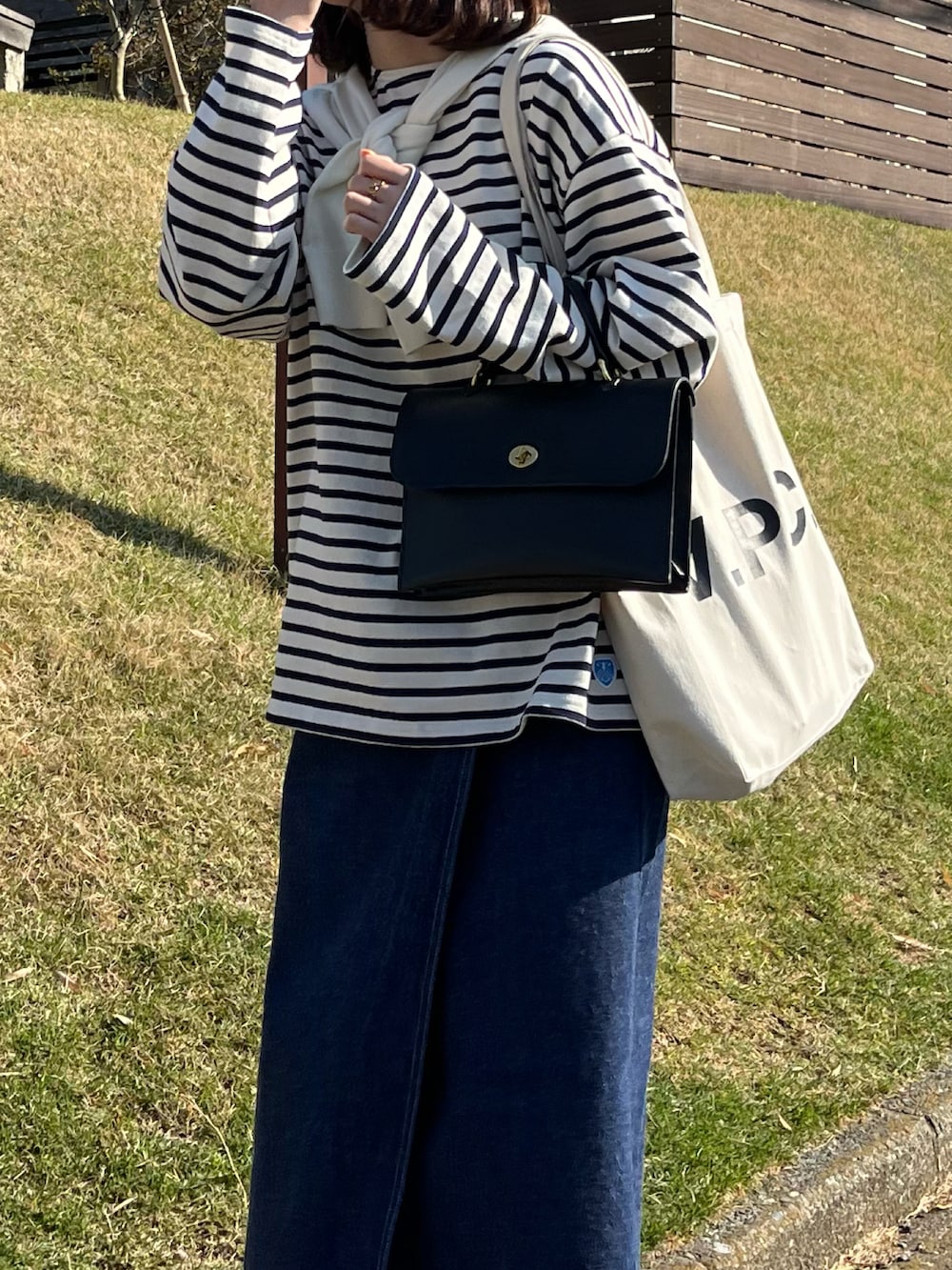 ブラック系のTシャツ/カットソー、ブラック系のショルダーバッグ、ホワイト系のトートバッグを着用したレディースの春コーディネートの2枚目の写真