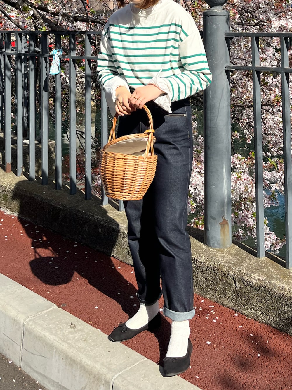 グリーン系のTシャツ/カットソー、ブラック系のバレエシューズ、ブルー系のデニムパンツを着用したレディースの春コーディネートの3枚目の写真