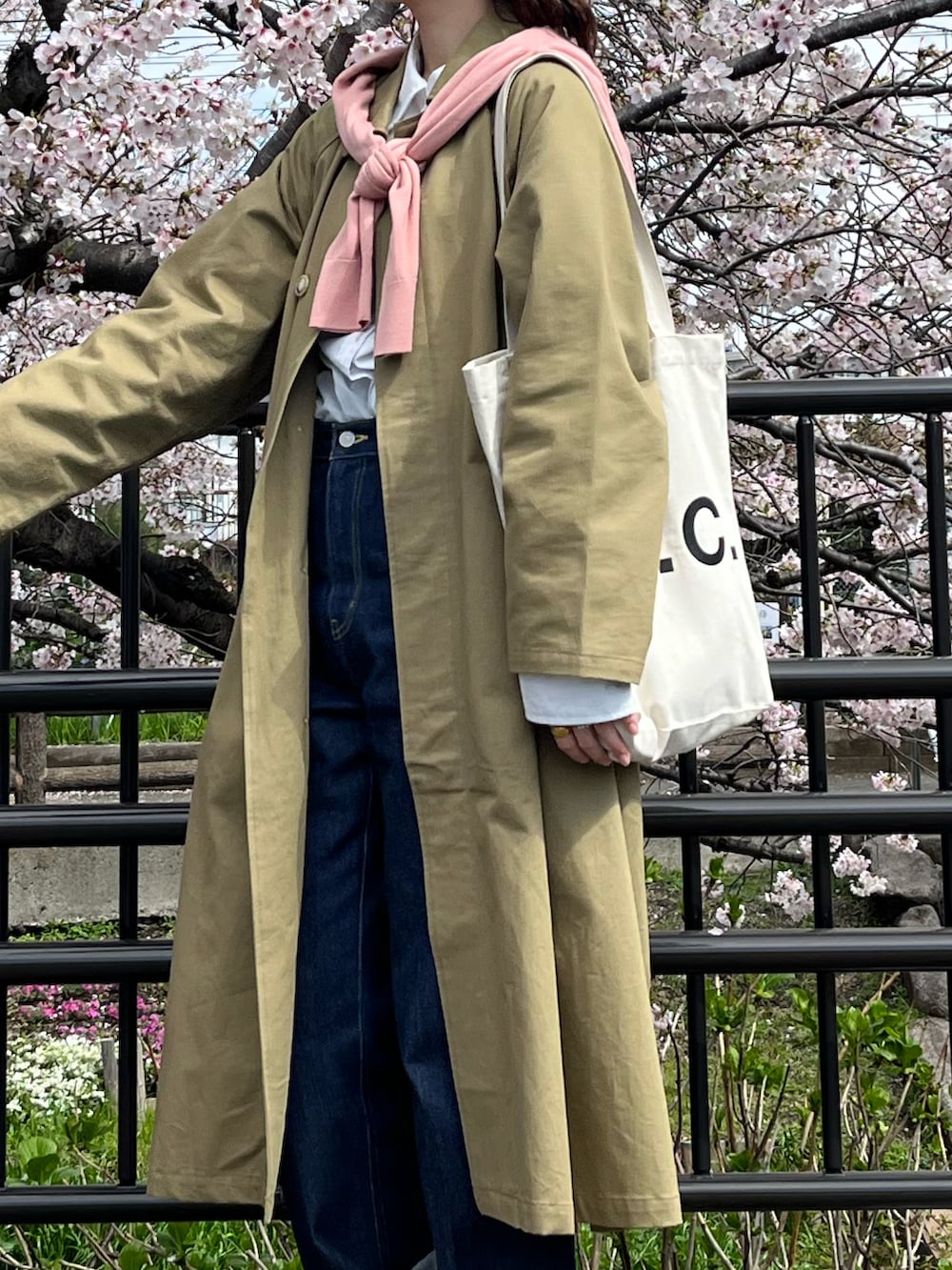 ブルー系のデニムパンツ、ホワイト系のトートバッグ、ホワイト系のシャツ/ブラウスを着用したレディースの春コーディネートの2枚目の写真