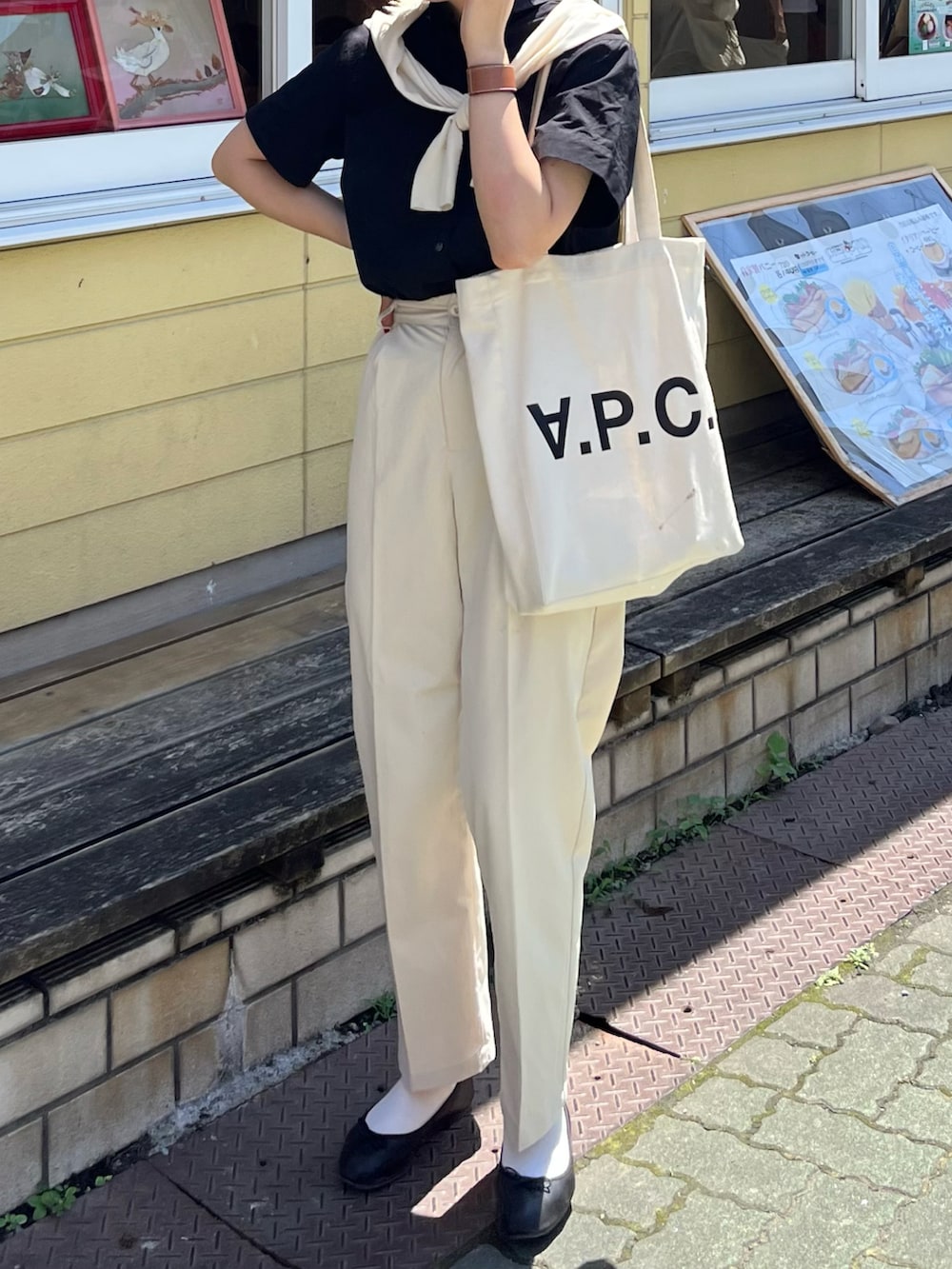 ホワイト系のチノパンツ、ホワイト系のトートバッグ、ブラック系のバレエシューズを着用したレディースの夏コーディネートの2枚目の写真