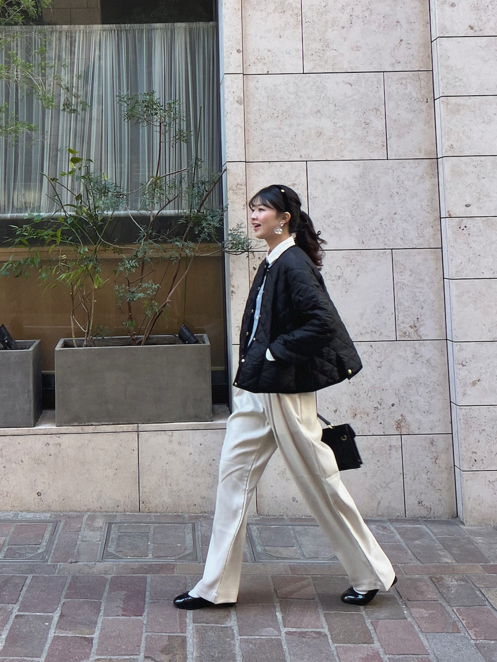 ブラック系のショルダーバッグ、ホワイト系のその他パンツ、ブラック系のその他アウターを着用したレディースの冬コーディネートの2枚目の写真