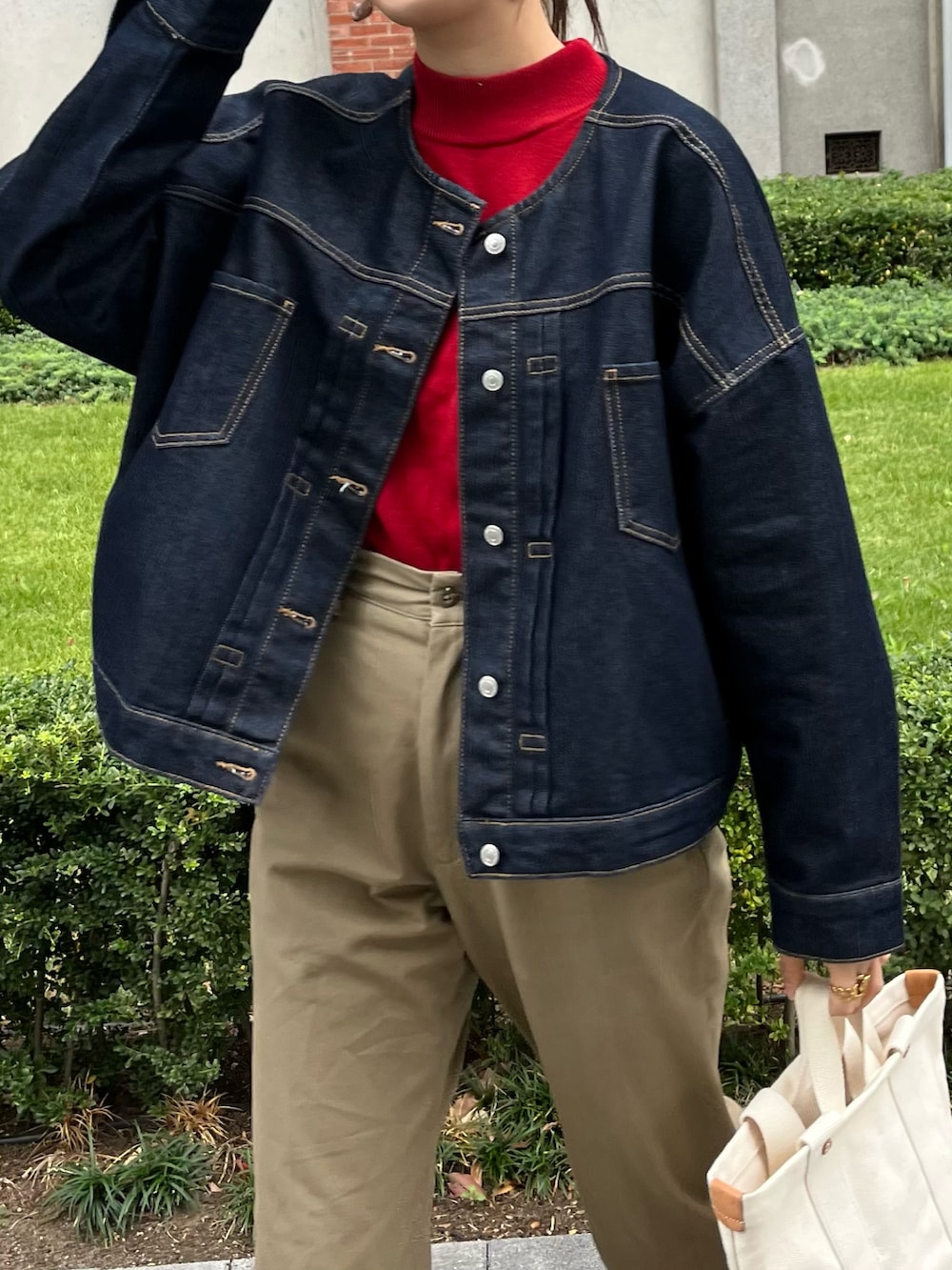 ベージュ系のチノパンツ、ブルー系のデニムジャケット、ブラウン系のドレスシューズを着用したレディースの秋コーディネートの2枚目の写真