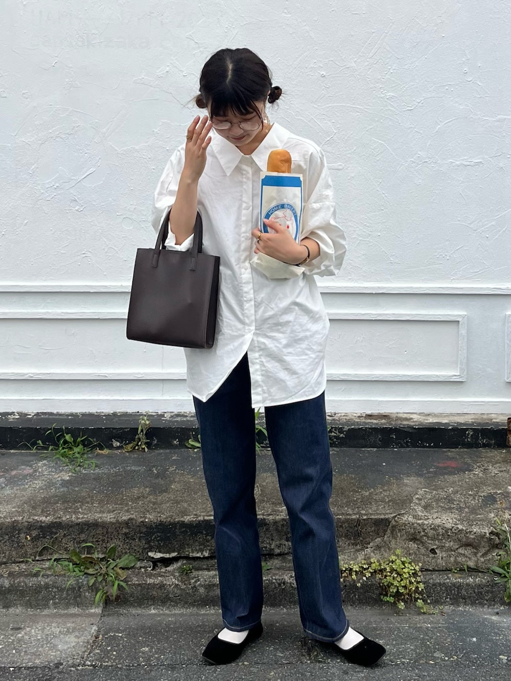 ブラウン系のショルダーバッグ、ホワイト系のシャツ/ブラウス、ブルー系のデニムパンツを着用したレディースの夏コーディネートの2枚目の写真