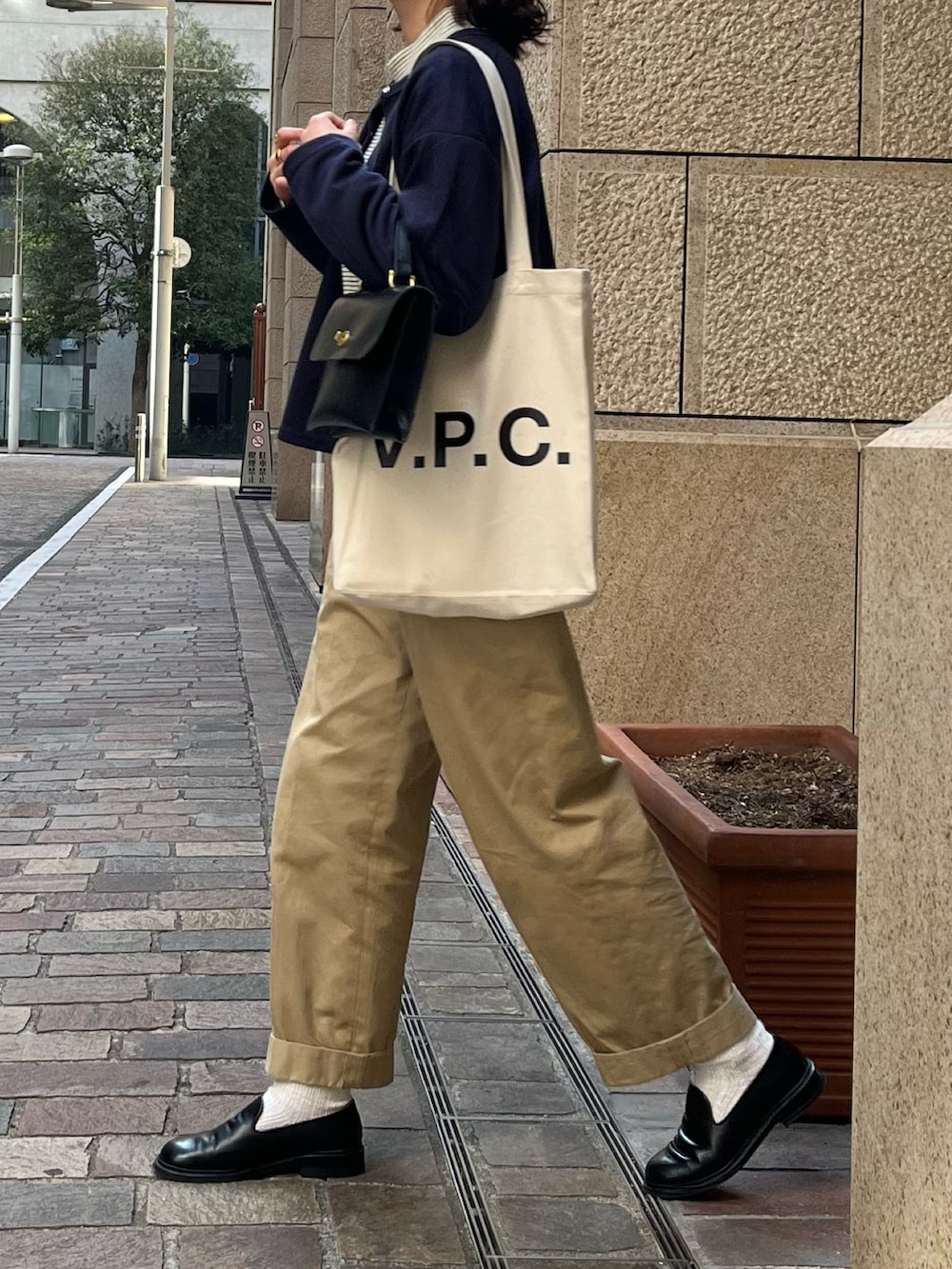 ブルー系のカーディガン/ボレロ、ホワイト系のトートバッグ、ブラック系のショルダーバッグを着用したレディースの冬コーディネートの2枚目の写真