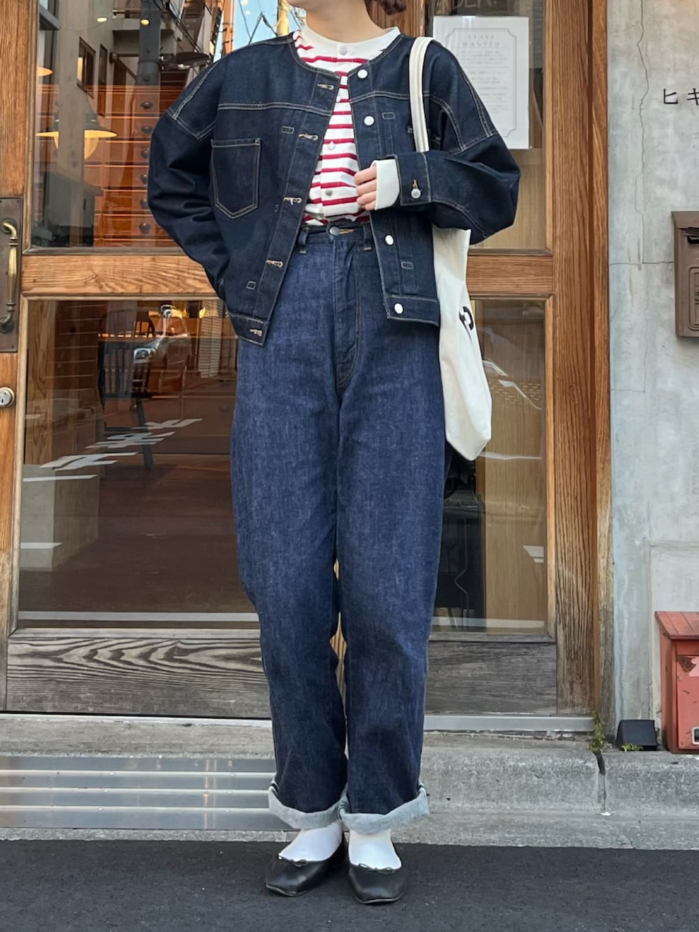 ブラック系のバレエシューズ、ブルー系のデニムパンツ、ブルー系のデニムジャケットを着用したレディースの秋コーディネートの2枚目の写真