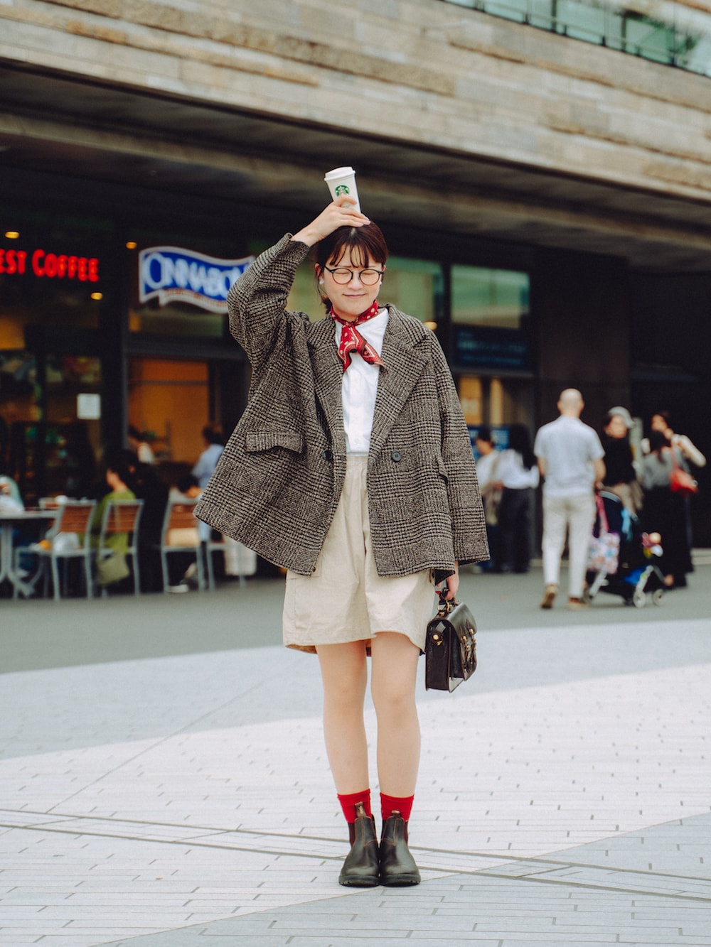 ブラウン系のブーツ、ブラウン系のショルダーバッグ、ベージュ系のスカートを着用したレディースの秋コーディネートの3枚目の写真