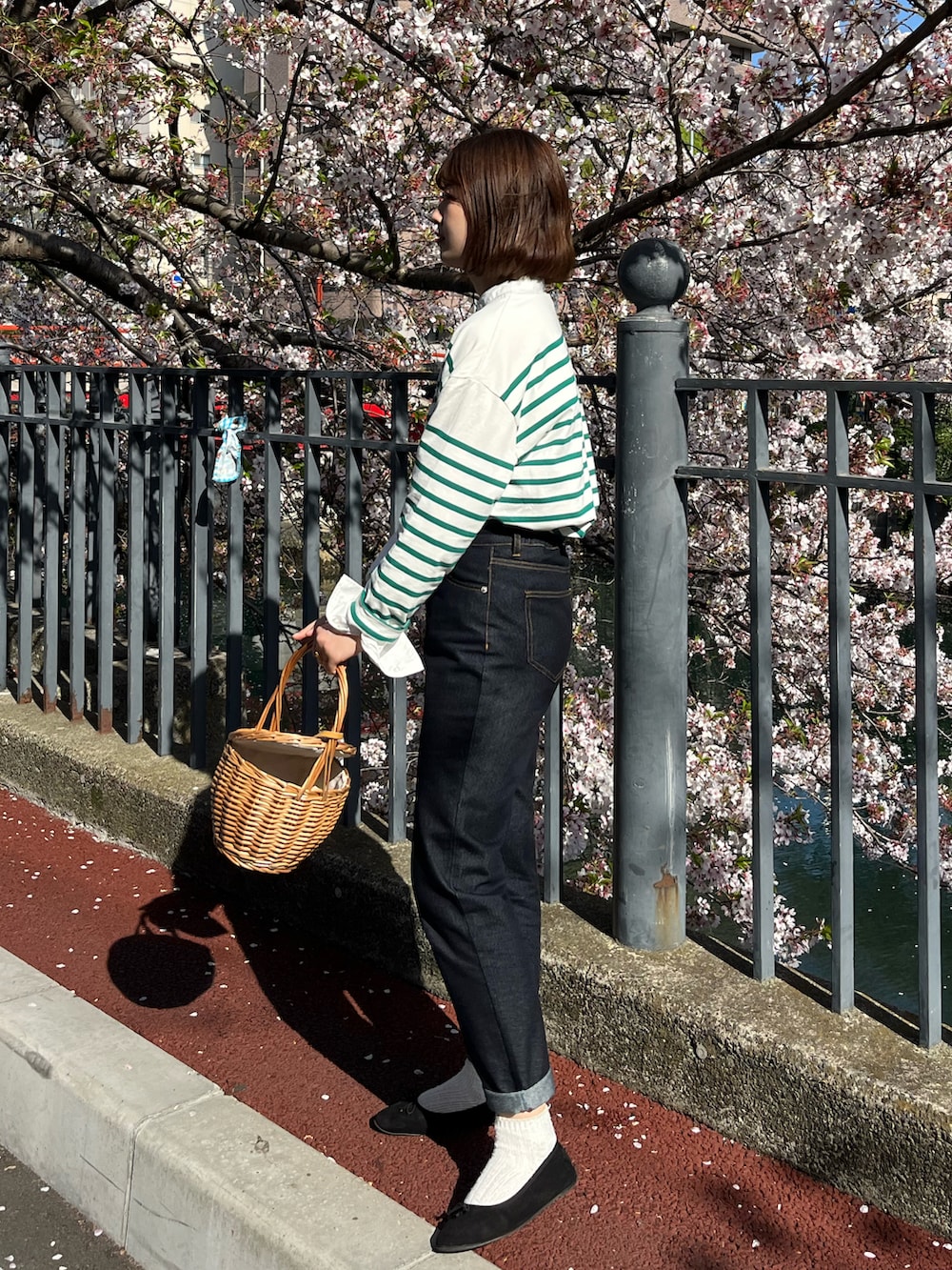 グリーン系のTシャツ/カットソー、ブラック系のバレエシューズ、ブルー系のデニムパンツを着用したレディースの春コーディネートの2枚目の写真