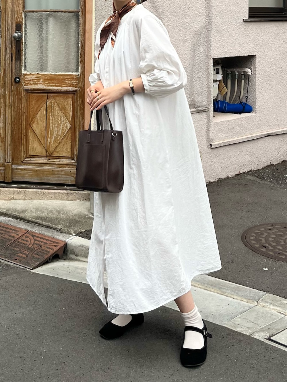 ブラウン系のショルダーバッグ、ホワイト系のワンピース、ブラック系のバレエシューズを着用したレディースの夏コーディネートの2枚目の写真