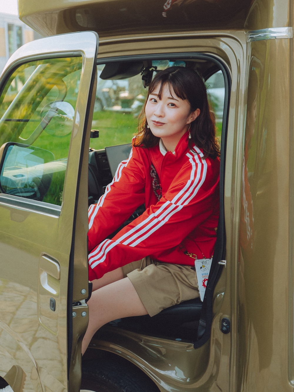 ブラウン系のモカシン/デッキシューズ、ベージュ系のその他パンツ、レッド系のジャージを着用したレディースの秋コーディネートの2枚目の写真