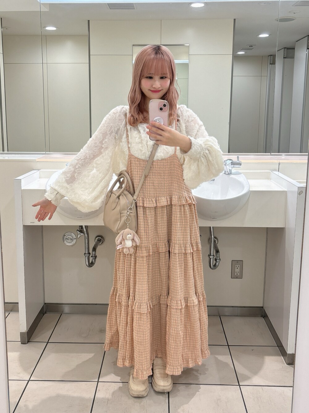 ピンク系のワンピース、ホワイト系のシャツ/ブラウス、グレー系のショルダーバッグを着用したレディースの秋コーディネートの2枚目の写真