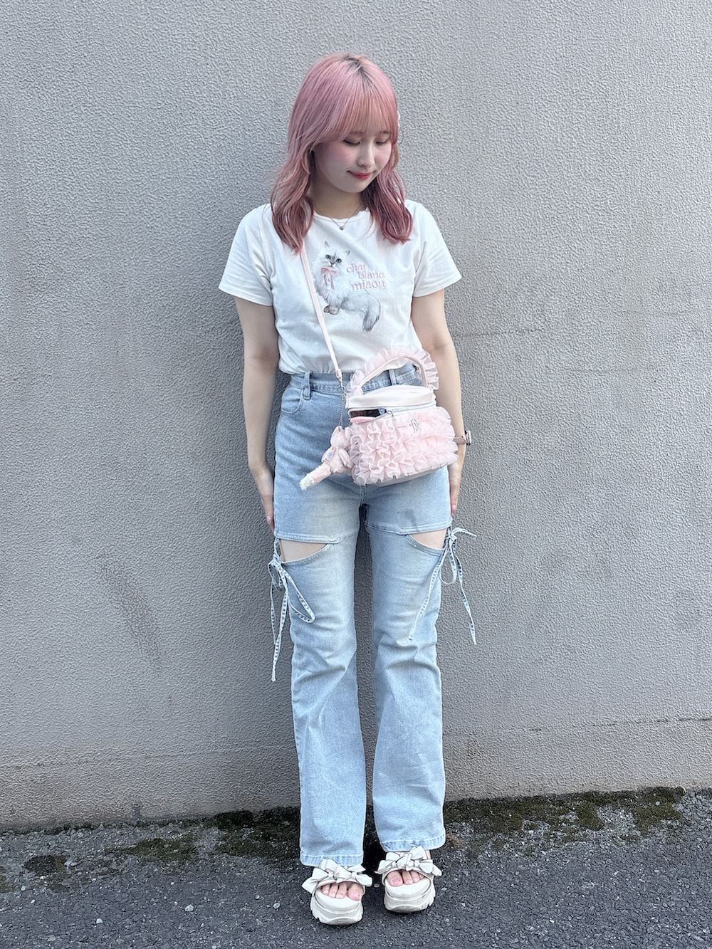 ブルー系のデニムパンツ、ホワイト系のTシャツ/カットソー、ピンク系のショルダーバッグを着用したレディースの夏コーディネートの2枚目の写真