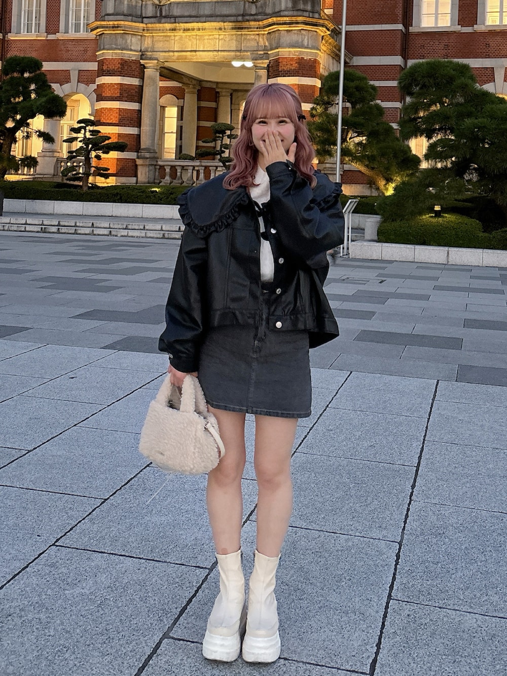 ブラック系のブルゾン、ホワイト系のニット/セーター、グレー系のデニムスカートを着用したレディースの秋コーディネートの2枚目の写真