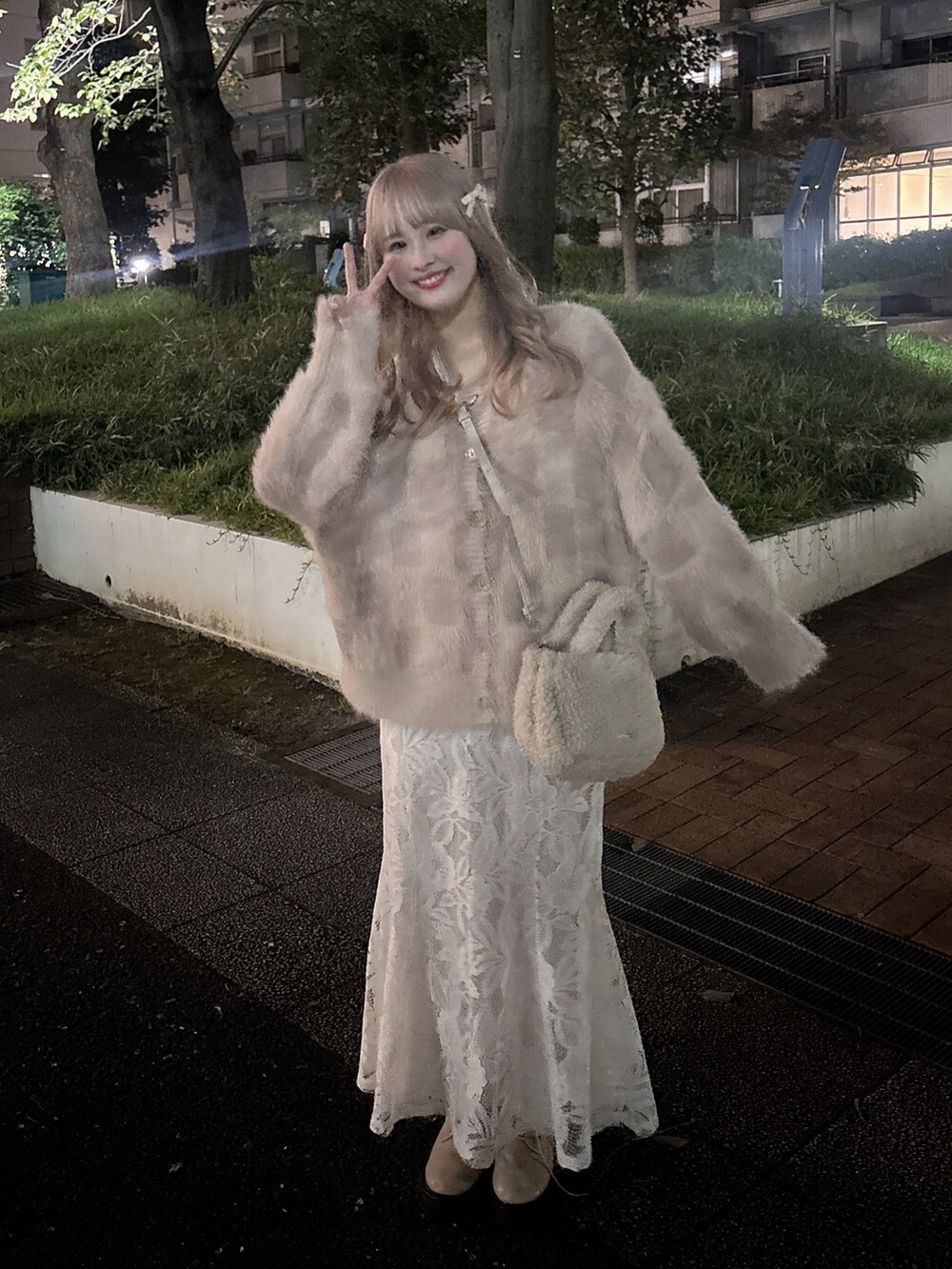 ピンク系のニット/セーター、ベージュ系のバッグ、ホワイト系のスカートを着用したレディースの秋コーディネートの2枚目の写真