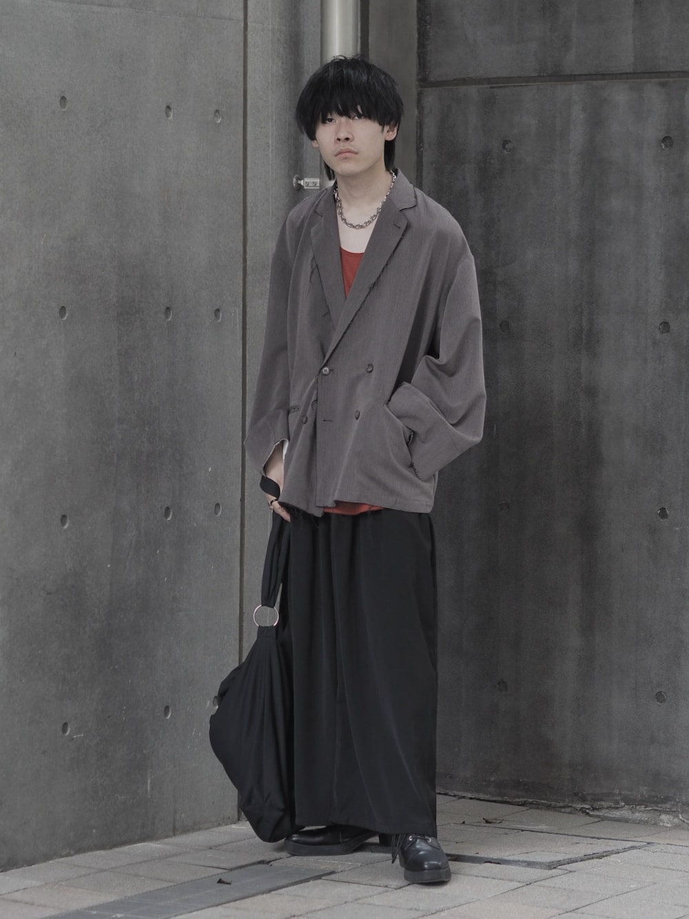 ブラウン系のテーラードジャケット、ブラウン系のタンクトップ、ブラック系のスカートを着用したメンズの夏コーディネートの5枚目の写真