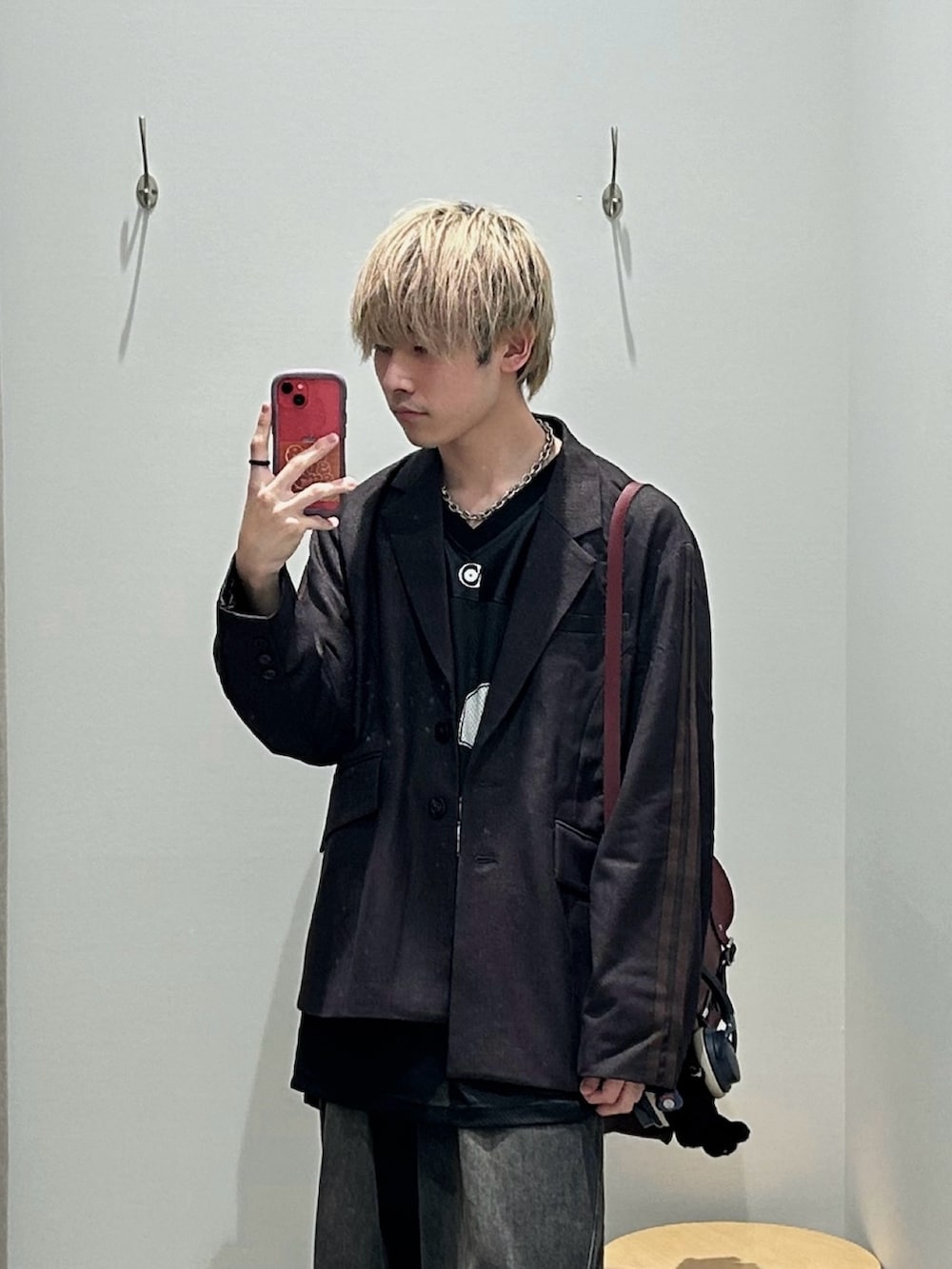 ブラウン系のテーラードジャケット、レッド系のショルダーバッグ、ブラック系のTシャツ/カットソーを着用したメンズの秋コーディネートの2枚目の写真