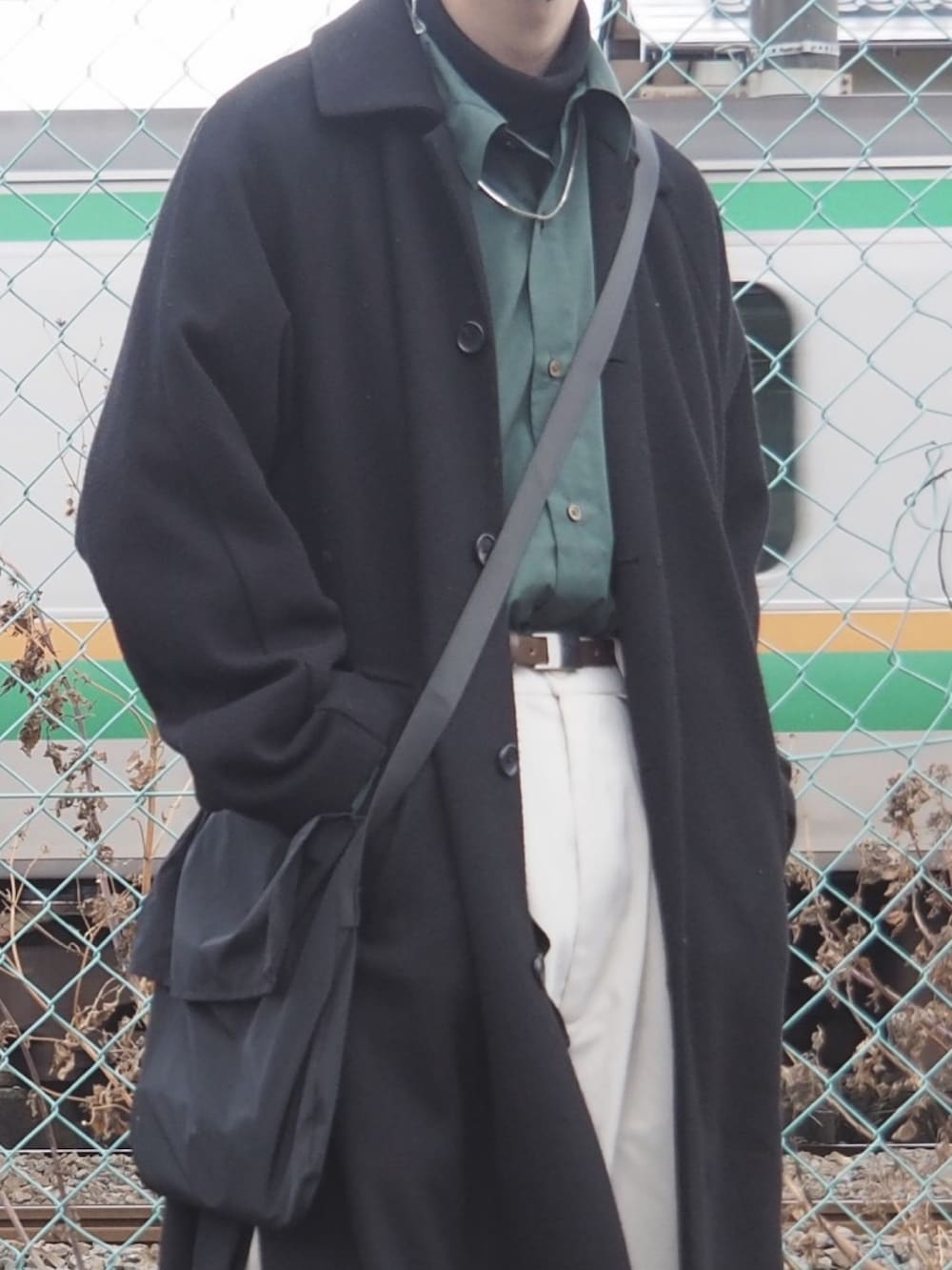 グリーン系のシャツ/ブラウス、ブラック系のTシャツ/カットソー、ブラック系のチェスターコートを着用したメンズの冬コーディネートの3枚目の写真