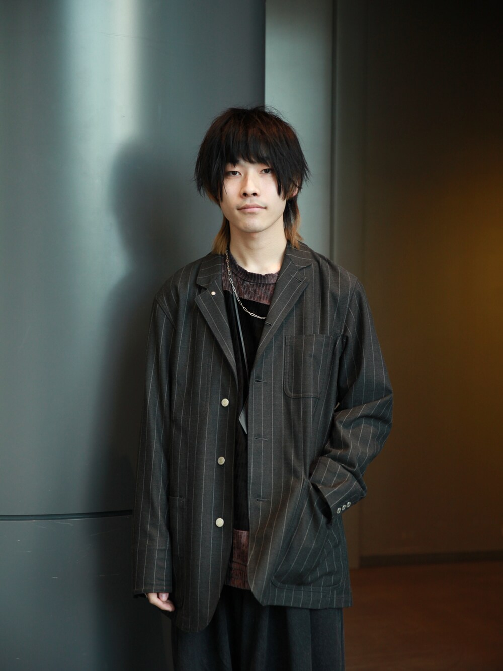 グレー系のカバーオール、ブラウン系のTシャツ/カットソー、ブルー系のデニムパンツを着用したメンズの冬コーディネートの2枚目の写真