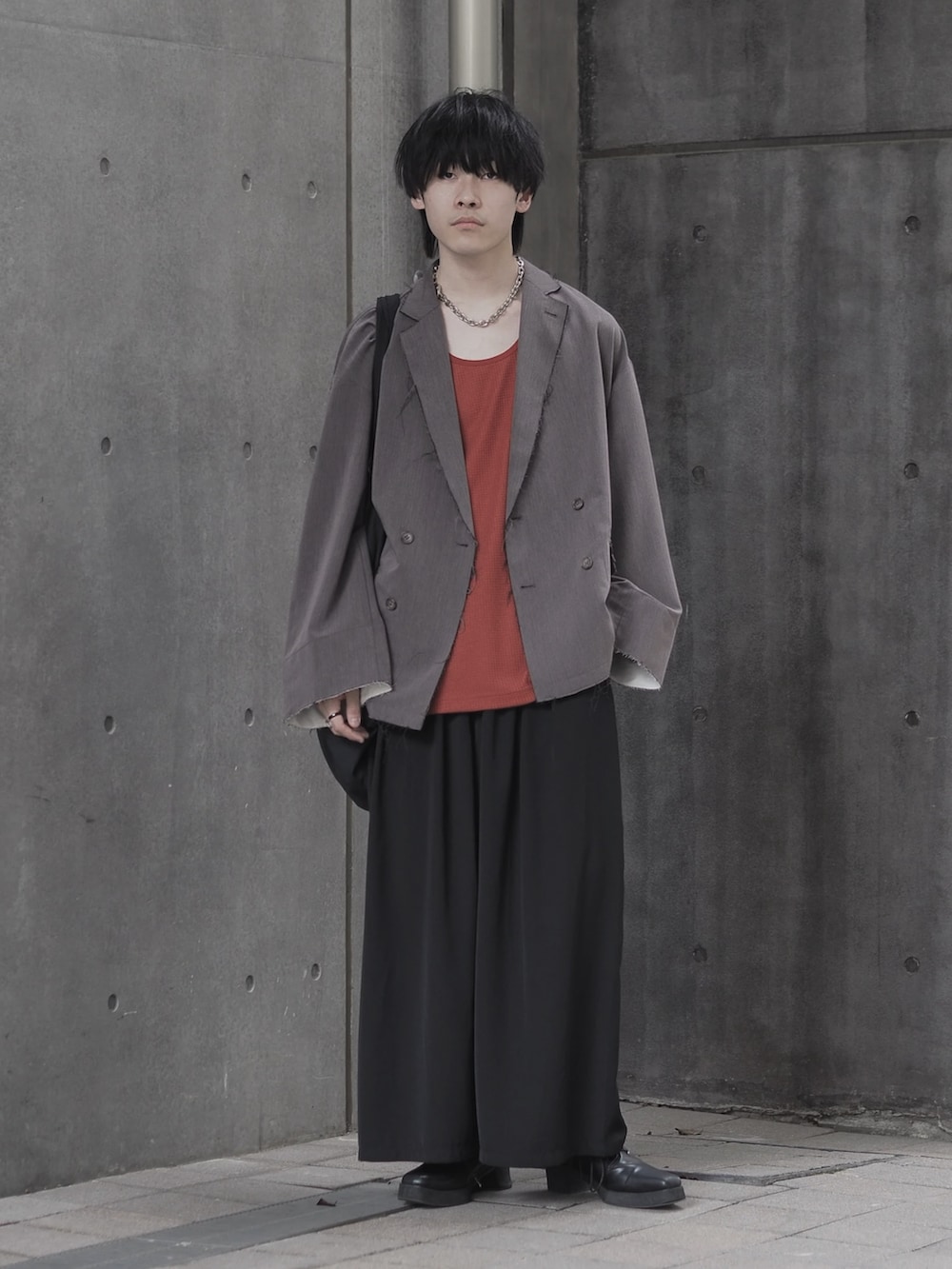 ブラウン系のテーラードジャケット、ブラウン系のタンクトップ、ブラック系のスカートを着用したメンズの夏コーディネートの3枚目の写真