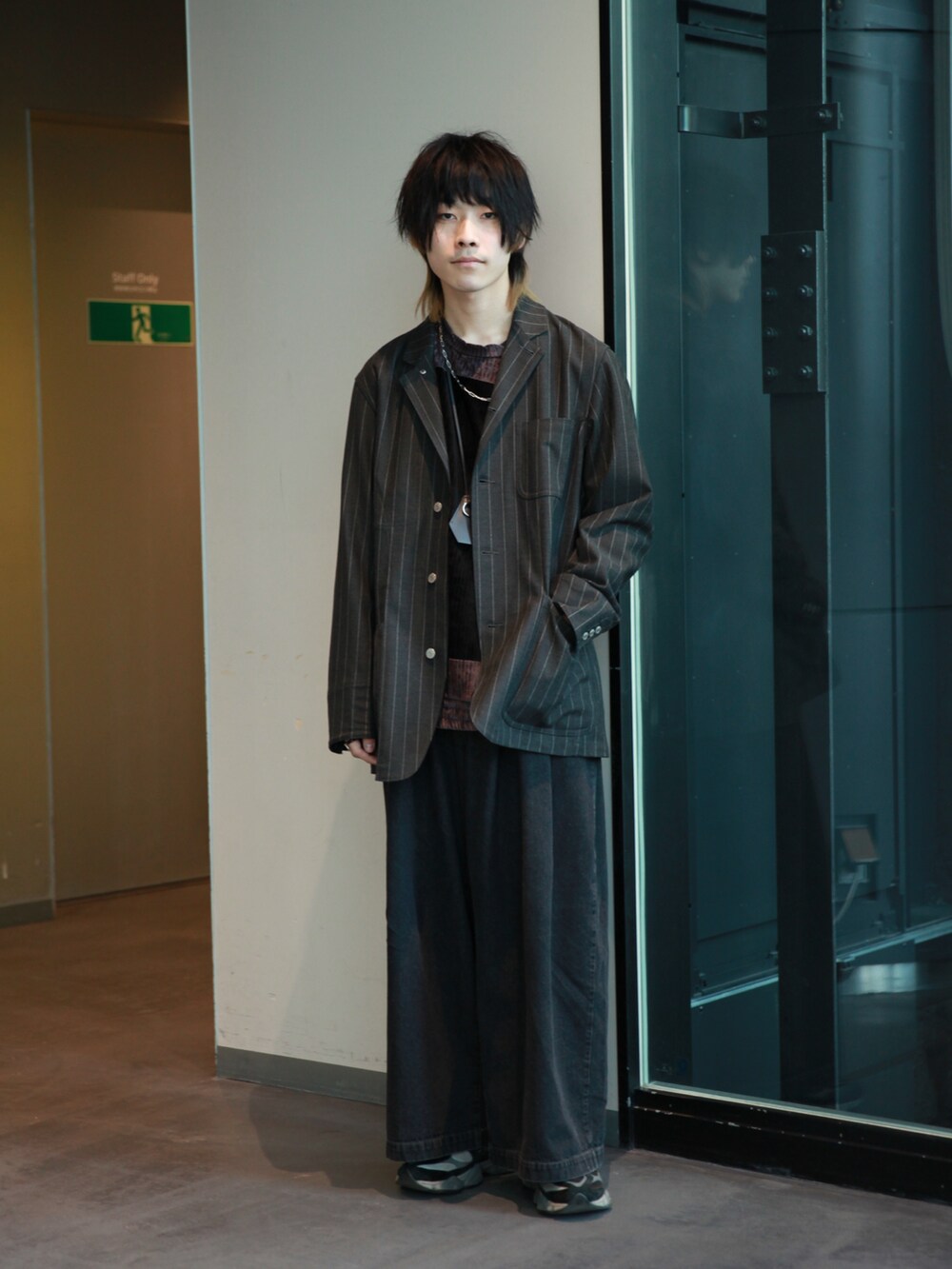 グレー系のカバーオール、ブラウン系のTシャツ/カットソー、ブルー系のデニムパンツを着用したメンズの冬コーディネートの4枚目の写真