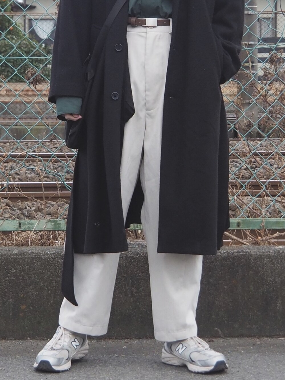 グリーン系のシャツ/ブラウス、ブラック系のTシャツ/カットソー、ブラック系のチェスターコートを着用したメンズの冬コーディネートの4枚目の写真