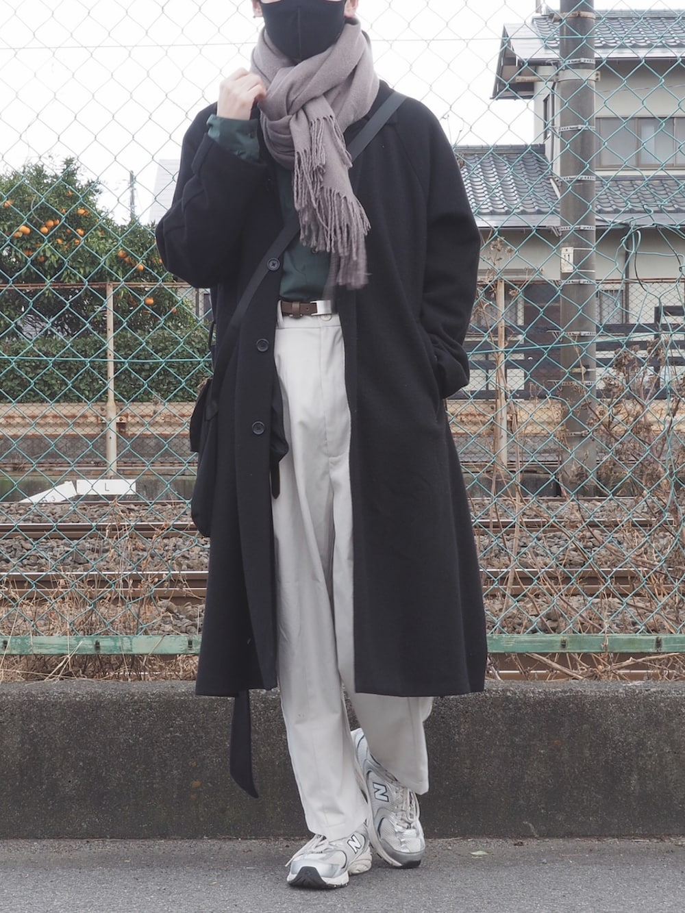 グリーン系のシャツ/ブラウス、ブラック系のTシャツ/カットソー、ブラック系のチェスターコートを着用したメンズの冬コーディネートの5枚目の写真