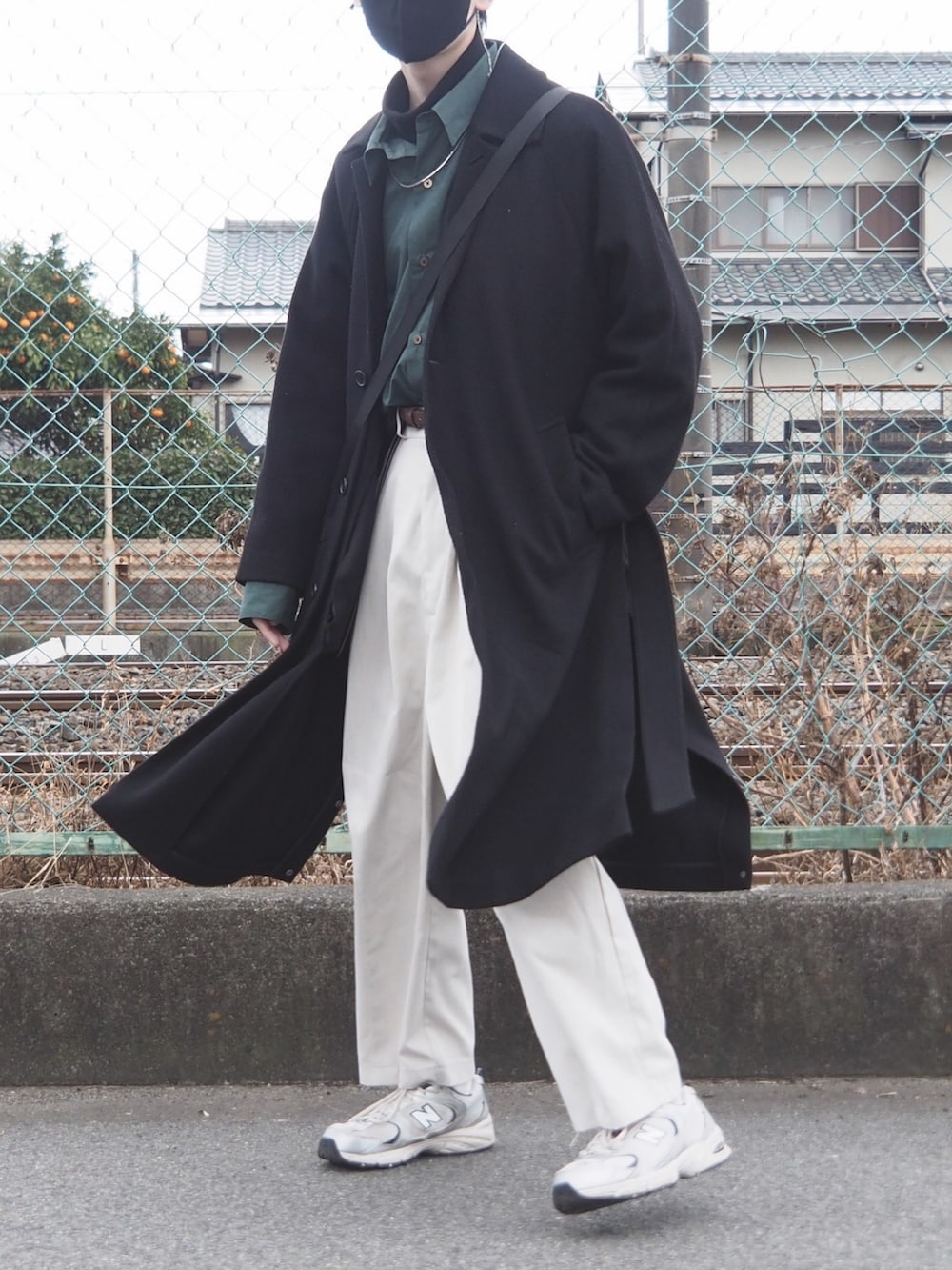 グリーン系のシャツ/ブラウス、ブラック系のTシャツ/カットソー、ブラック系のチェスターコートを着用したメンズの冬コーディネートの2枚目の写真