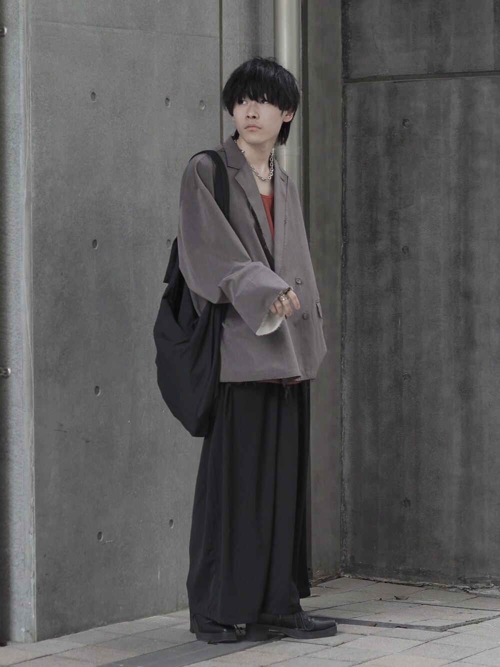 ブラウン系のテーラードジャケット、ブラウン系のタンクトップ、ブラック系のスカートを着用したメンズの夏コーディネートの4枚目の写真