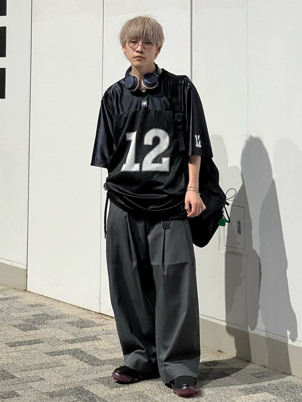 グレー系のその他パンツ、ブラック系のTシャツ/カットソー、ブラック系のスニーカーを着用したメンズの秋コーディネートの2枚目の写真