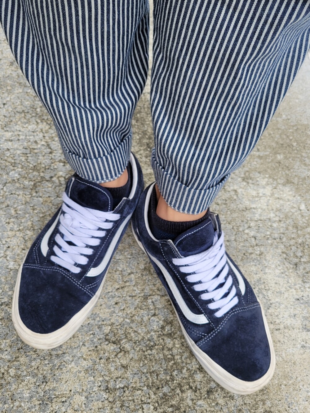 ブルー系のスニーカー、ブルー系のパンツ、ホワイト系のタンクトップを着用したメンズの秋コーディネートの3枚目の写真