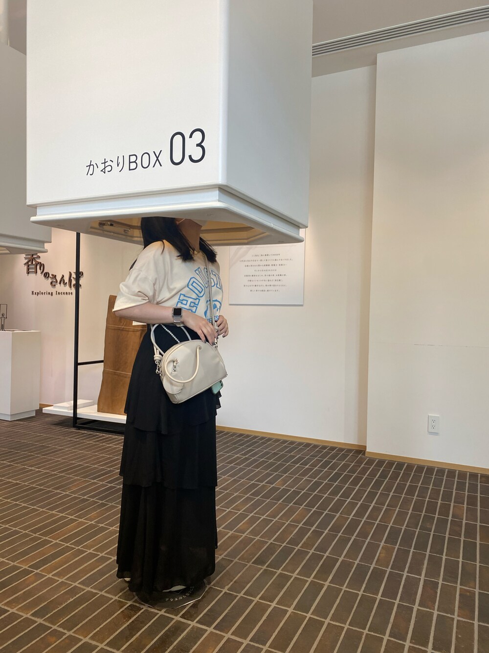 ホワイト系のワンピース、ブルー系のTシャツ/カットソー、ベージュ系のショルダーバッグを着用したレディースの秋コーディネートの3枚目の写真