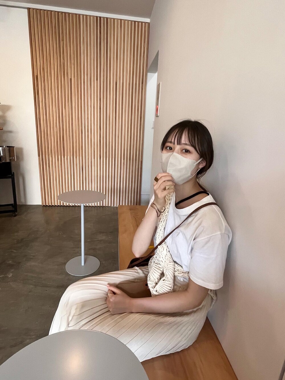 ホワイト系のスカート、ベージュ系のトップスを着用したレディースの秋コーディネートの2枚目の写真