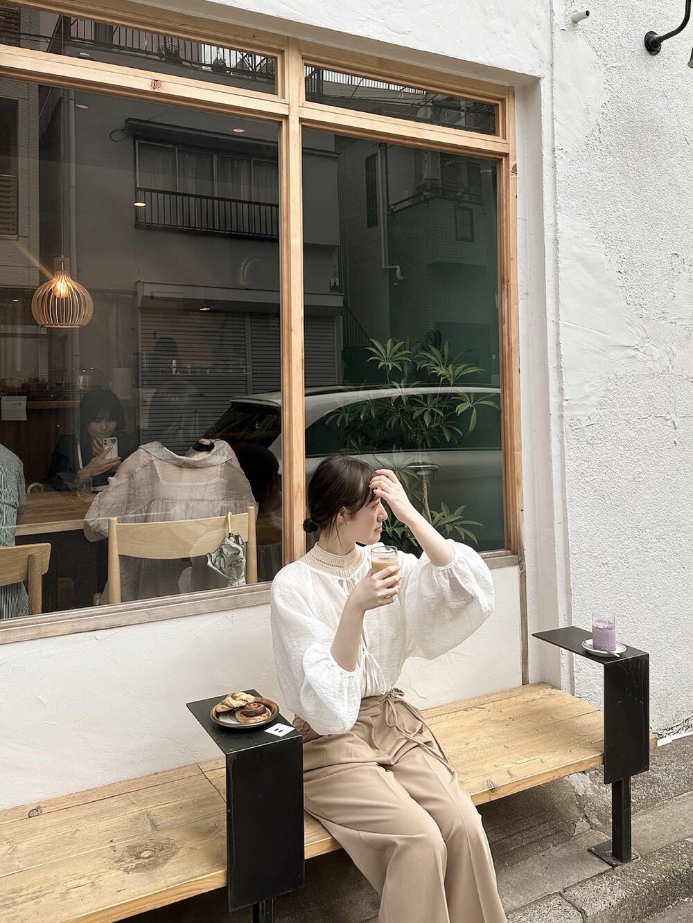 ベージュ系のスラックス、ホワイト系のシャツ/ブラウス、ベージュ系のニット/セーターを着用したレディースの夏コーディネートの3枚目の写真