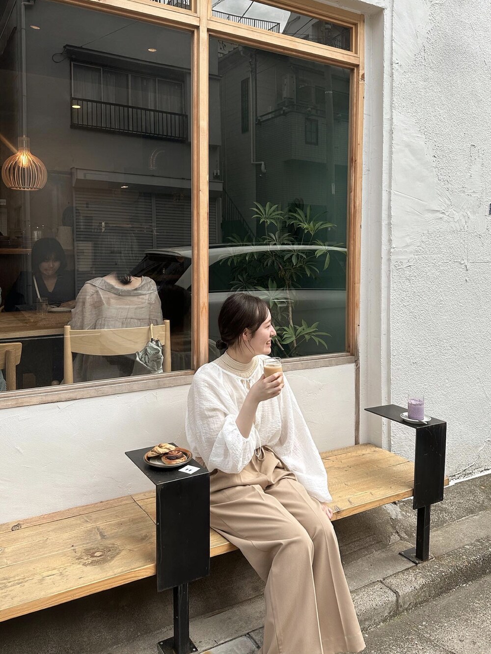 ベージュ系のスラックス、ホワイト系のシャツ/ブラウス、ベージュ系のニット/セーターを着用したレディースの夏コーディネートの2枚目の写真