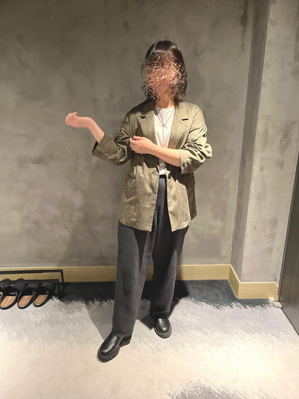 グレー系のパンツ、ホワイト系のTシャツ/カットソー、ブラック系のブーツを着用したレディースの秋コーディネートの2枚目の写真