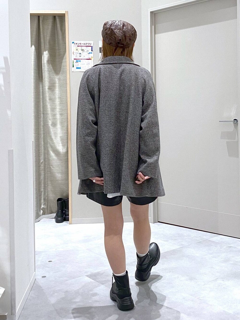 グレー系のチェスターコート、ブラウン系のニット/セーター、ブラック系のショルダーバッグを着用したレディースの秋コーディネートの3枚目の写真