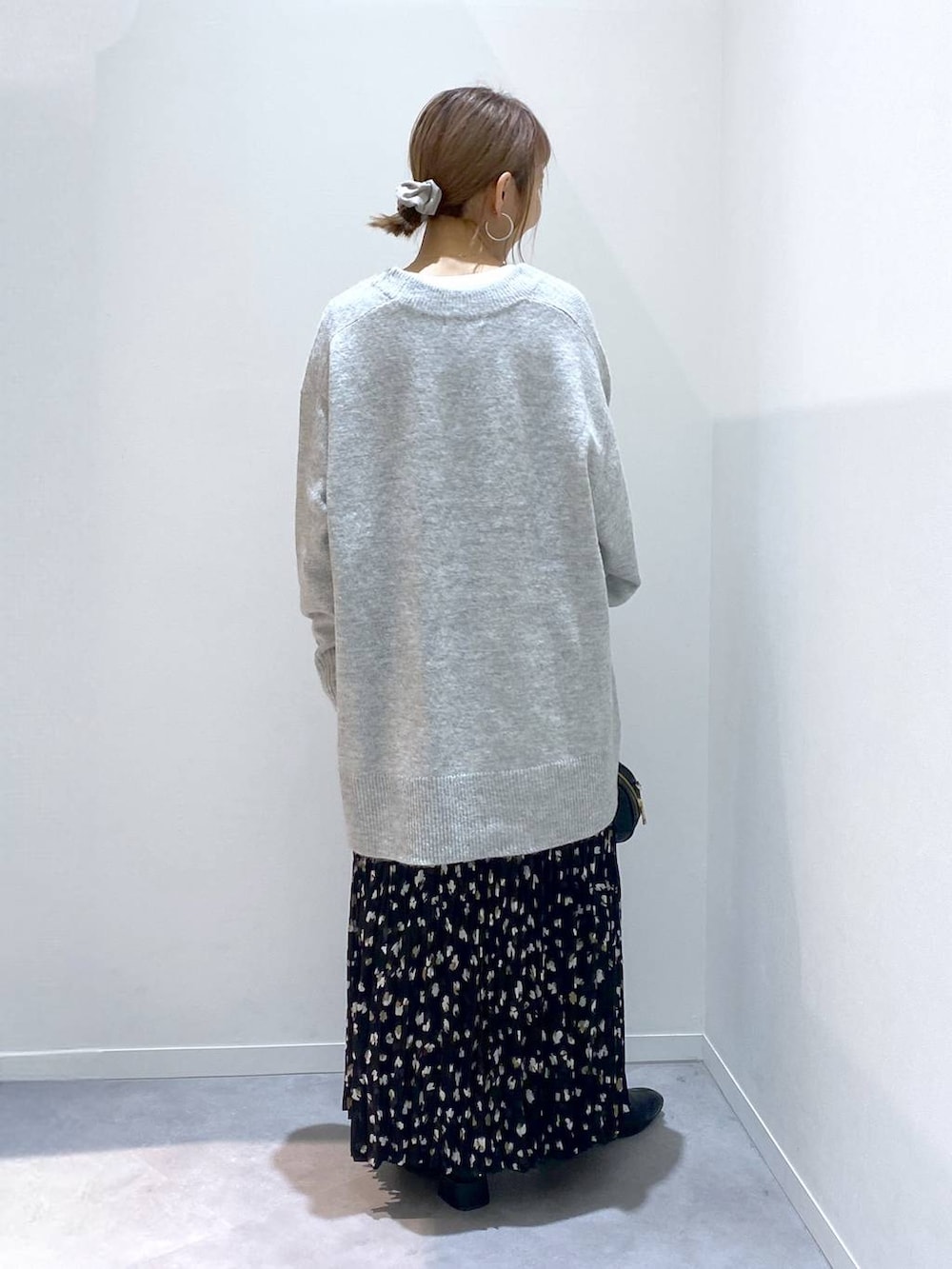 グレー系のニット/セーター、ホワイト系のTシャツ/カットソー、ブラック系のハンドバッグを着用したレディースの秋コーディネートの3枚目の写真