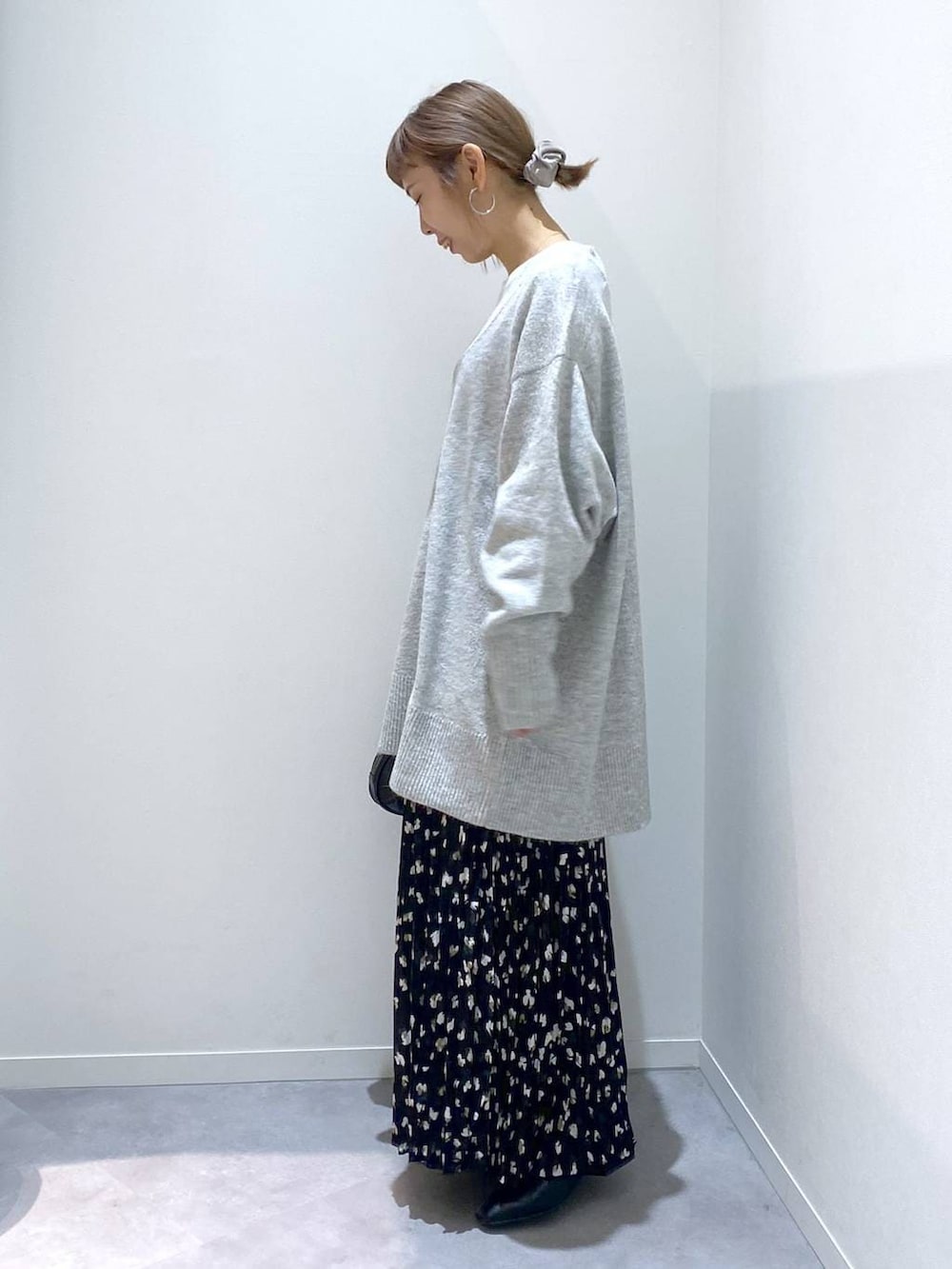 グレー系のニット/セーター、ホワイト系のTシャツ/カットソー、ブラック系のハンドバッグを着用したレディースの秋コーディネートの2枚目の写真