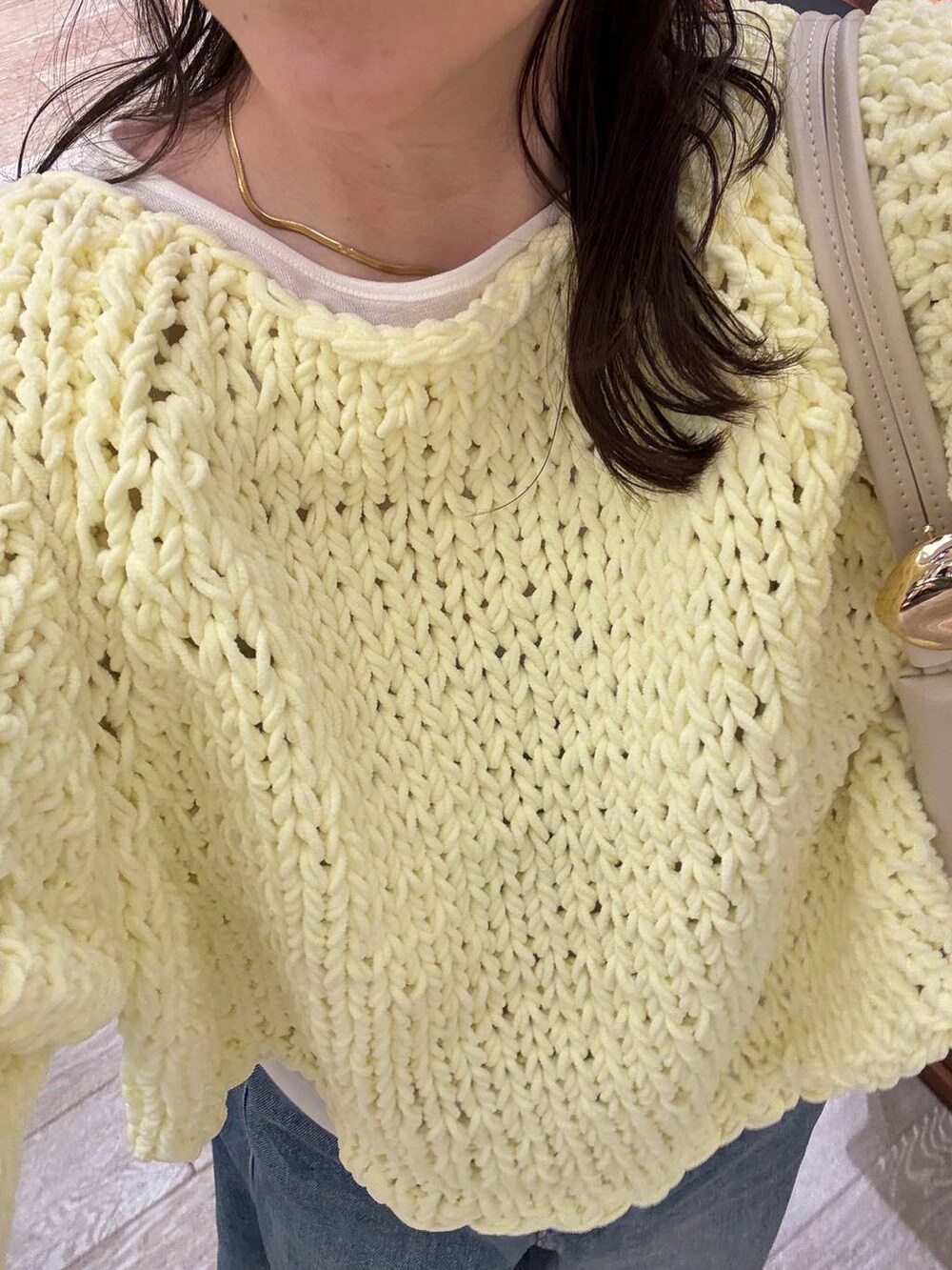 ブルー系のデニムパンツ、イエロー系のニット/セーター、ホワイト系のTシャツ/カットソーを着用したレディースの冬コーディネートの5枚目の写真