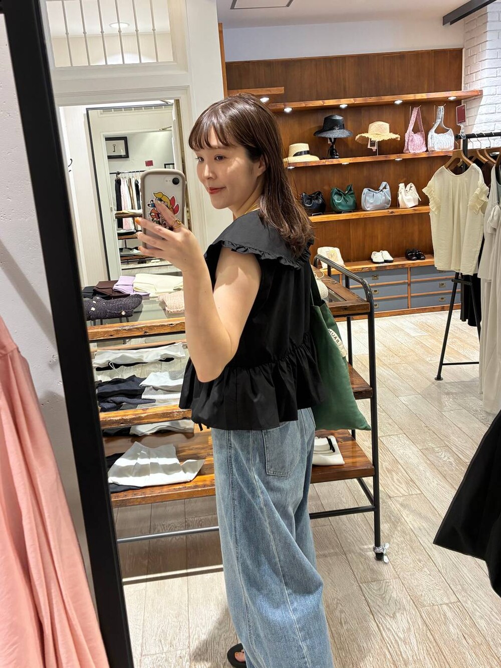 ブルー系のデニムパンツ、ブラック系のシャツ/ブラウスを着用したレディースの夏コーディネートの4枚目の写真