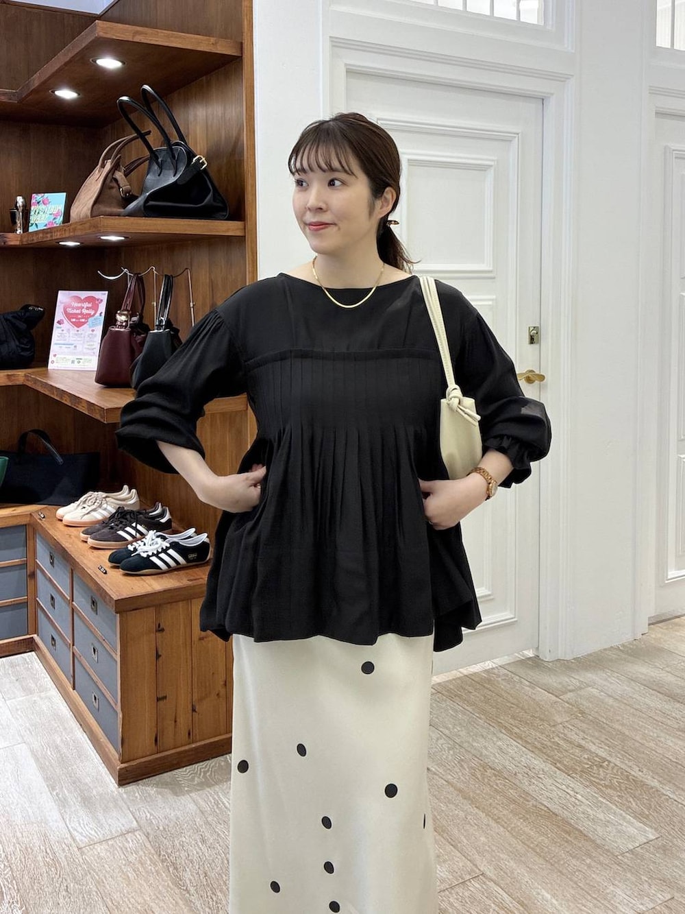 ホワイト系のスカート、ブラック系のシャツ/ブラウス、ゴールド系のバレッタ/ヘアクリップを着用したレディースの冬コーディネートの4枚目の写真