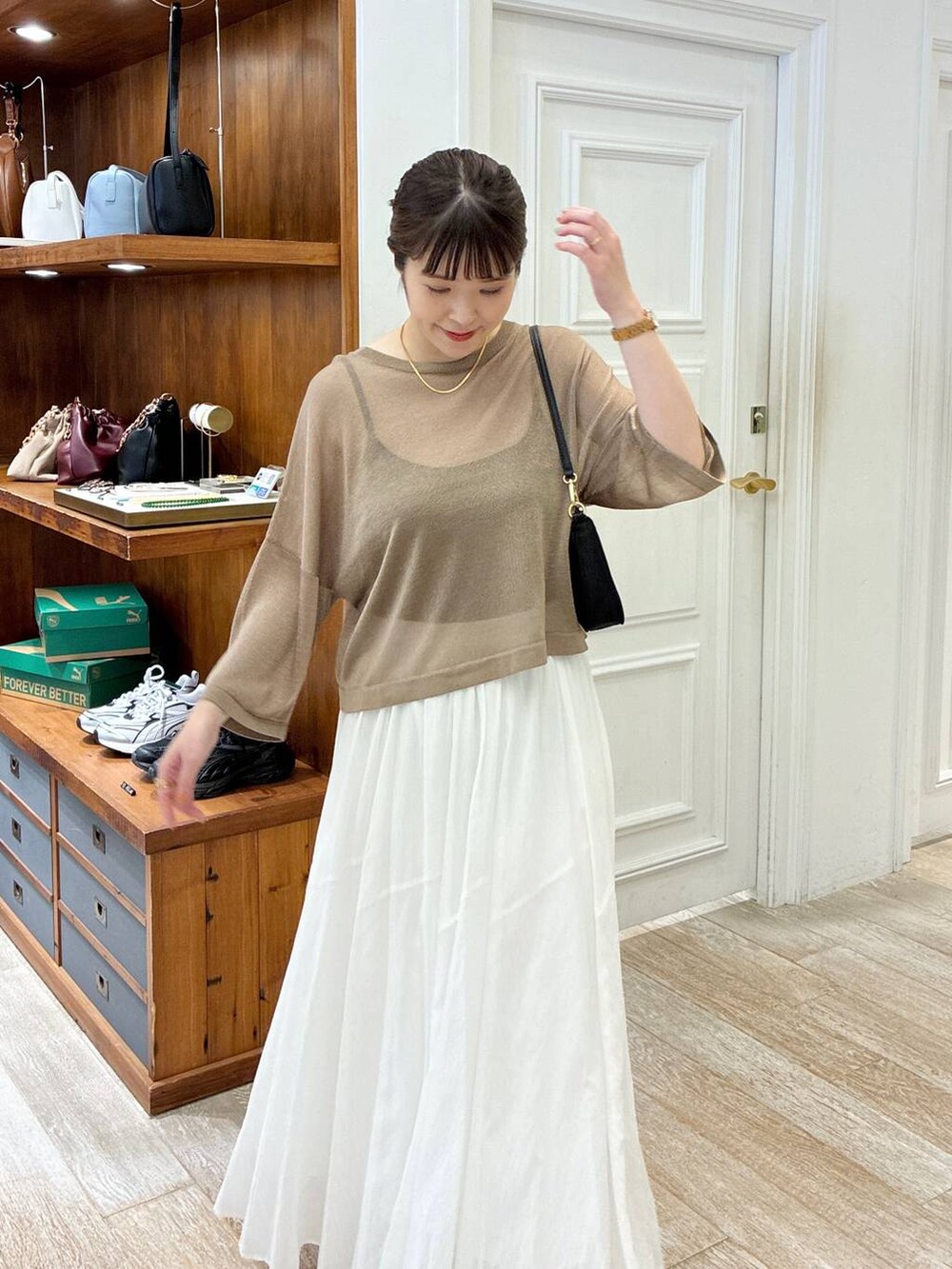 ブラック系のサンダル、ホワイト系のスカート、イエロー系のニット/セーターを着用したレディースの夏コーディネートの4枚目の写真